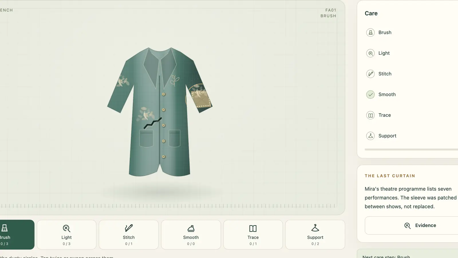 Fashion Archive: a green coat with floral motifs, a patched sleeve and a dark tear on a pale work surface.